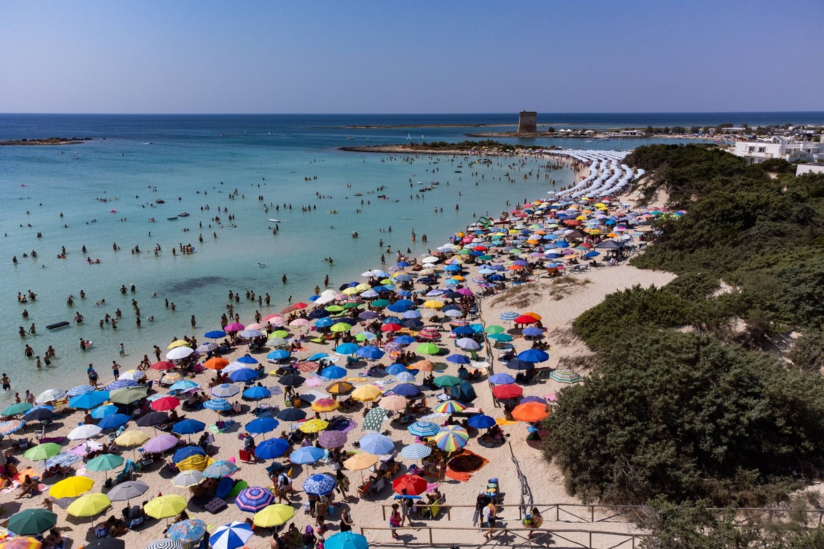 Heatwave In Salento, Italy An aerial drone view shows colored umbrellas and people on a crowded beach in Scala di Furno, Porto Cesareo, Salento, Italy on august 21, 2023. A new heatwave and vacation t ...