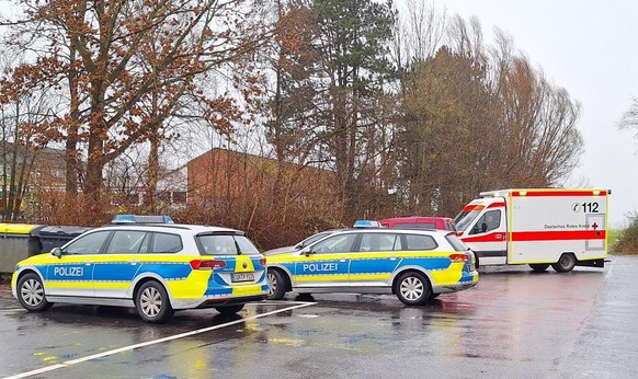 21.12.2023, Niedersachsen, Cuxhaven: Polizeiautos und ein Krankenwagen stehen nahe einer Schule. Vor den Augen ihrer Mitschüler hat eine Jugendliche am Donnerstagmorgen ein anderes Mädchen in einer Gr ...