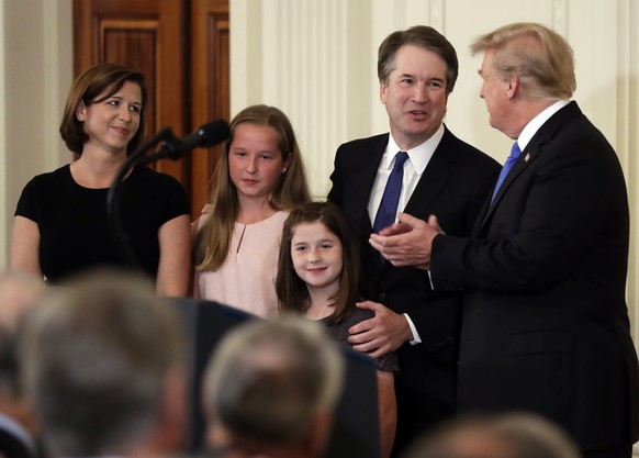 FILE - In this July 9, 2018, file photo, President Donald Trump greets Judge Brett Kavanaugh his Supreme Court nominee, in the East Room of the White House in Washington. Watching is wife Ashley, with ...