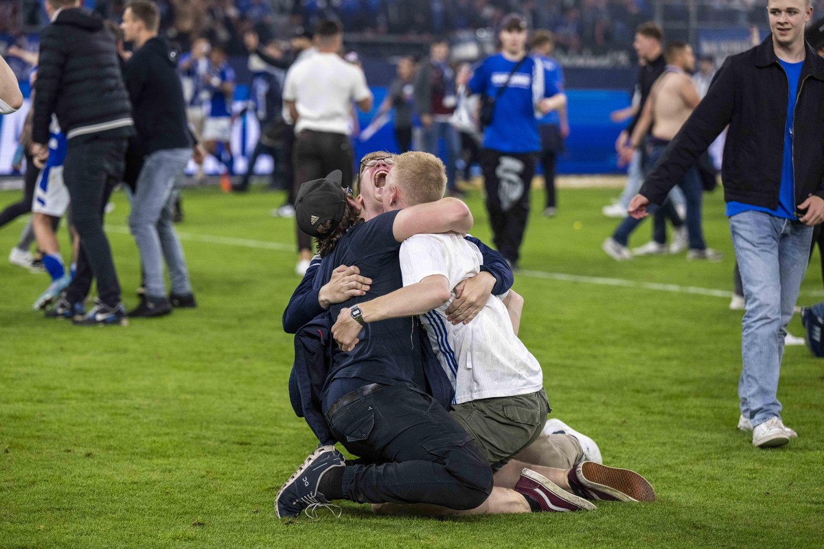 Fußball: 2. Bundesliga, FC Schalke 04 - FC St. Pauli, 33. Spieltag, Veltins Arena: Schalker Fans haben den Rasen gestürmt und bejubeln den Aufstieg.
