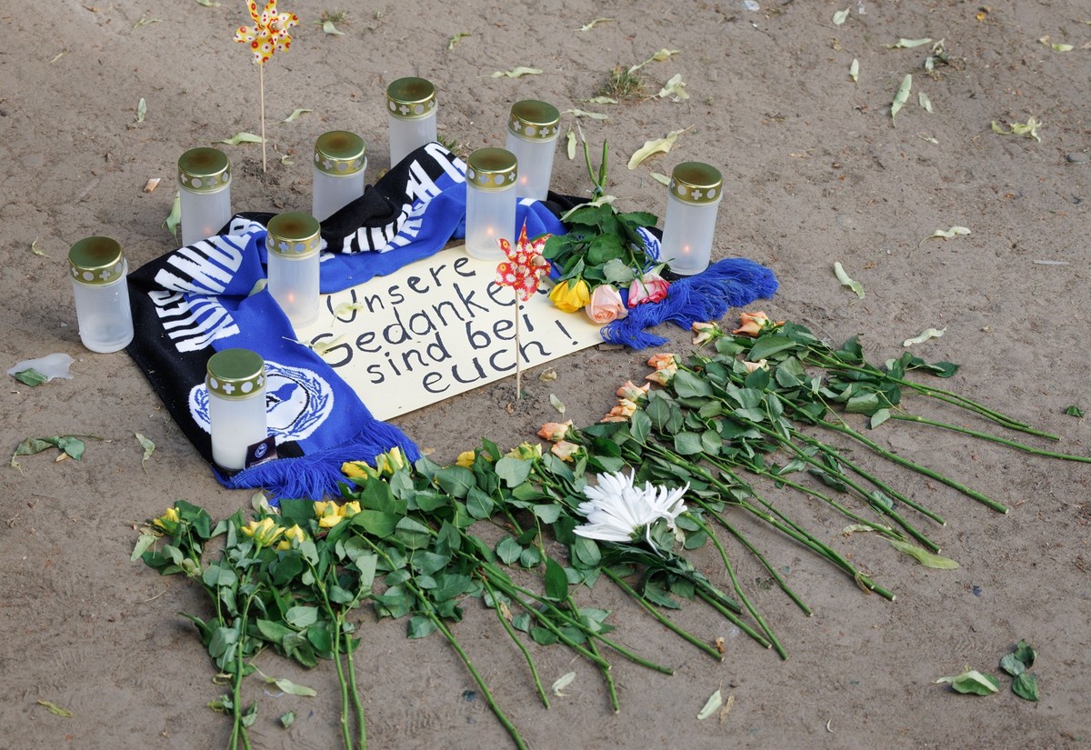 dpatopbilder - 20.05.2025, Nordrhein-Westfalen, Bielefeld: Kerzen und ein Fanschal von Arminia Bielefeld sind an einem Tatort in der Innenstadt zu sehen. Nach dem Angriff eines Mannes auf mindestens f ...