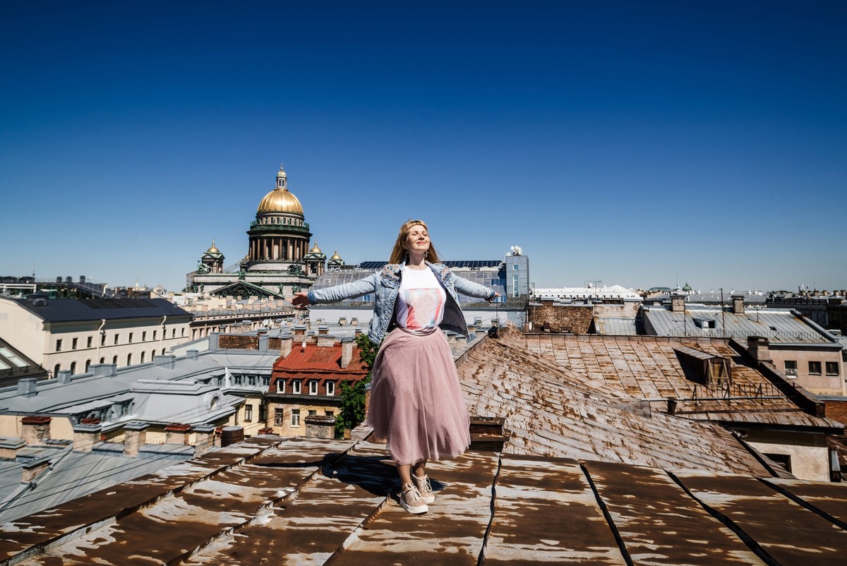 young happy woman tourist on the rooftop of a european city overlooking the cathedral colonnade