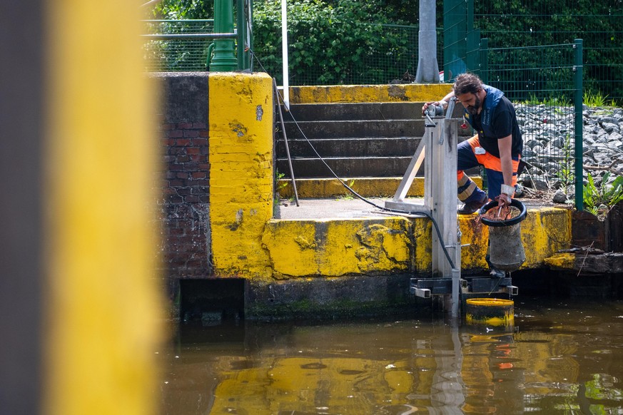 NPorts-Mitarbeiter Björn Fuhlendorf leert den Meeresmülleimer, der schwimmenden Abfall im Hafenbecken einsammelt.