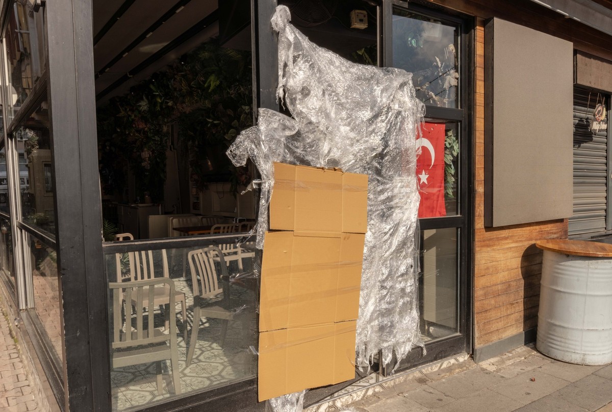 14.11.2025, Türkei, Istanbul: An einem türkischen Stand für Streetfood, der von den türkischen Behörden geschlossen wurde, hängen eine Pappe und eine Plastikplane neben einer türkischen Fahne. Streetf ...