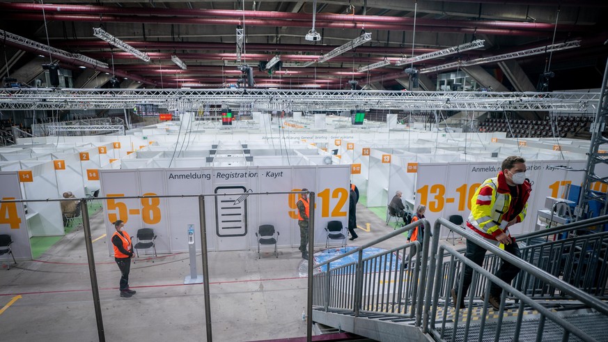 Helfer stehen bei der Eröffnung des zweiten Impfzentrum Berlins, im Erika-Hess-Eissatdion. Hier können sich zunächst ältere Menschen nach einer Einladung gegen das Coronavirus impfen lassen.