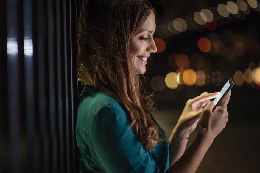 Woman stranding outside and texting