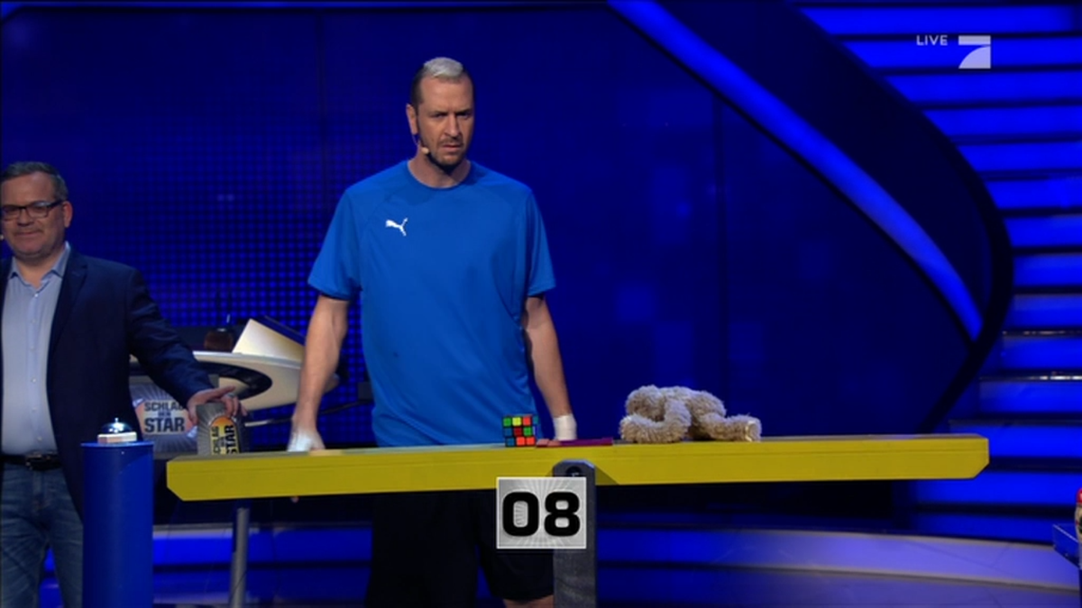 Pascal Hens balanciert einen Zauberwürfel und ein Kuscheltier aus.