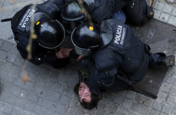 Catalan Mossos d&#039;Esquadra regional police officers detain a man during clashes with pro-independence supporters trying to reach the Spanish government office in Barcelona, Spain, Sunday, March 25 ...