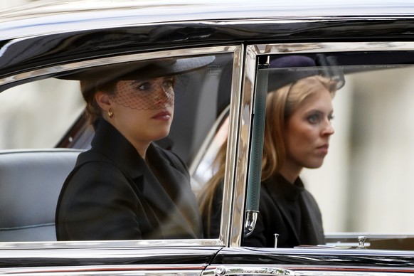 19.09.2022, Gro�britannien, London: Prinzessin Eugenie (l) und Prinzessin Beatrice verlassen Westminster Abbey nach dem Staatsakt vor der Beisetzung von K�nigin Elizabeth II in einem Wagen. Zum Staats ...
