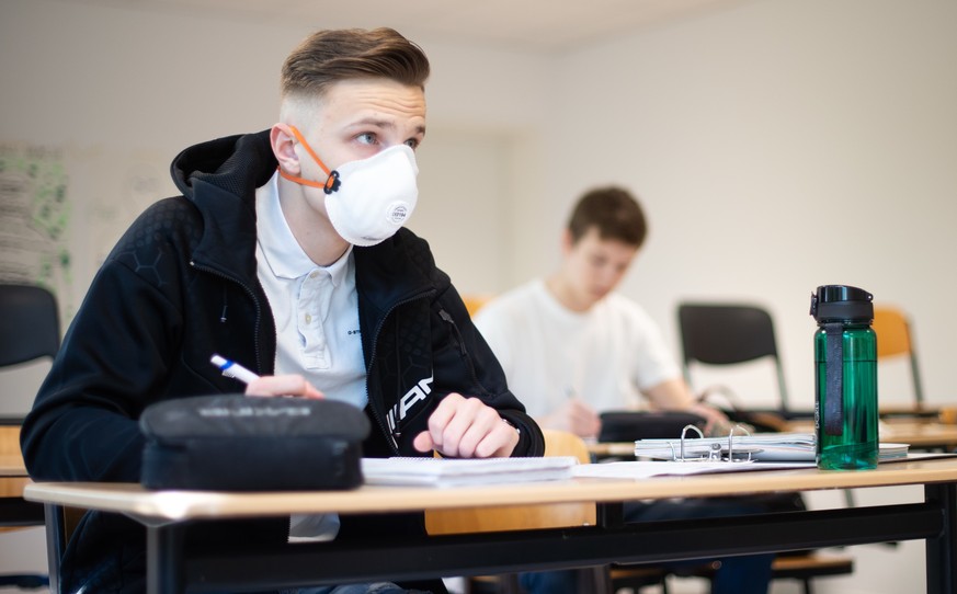 Zwei Schüler, einer davon mit einer Schutzmaske, bearbeiten Informatikaufgaben im Informatik-Grundkurs eines Abiturjahrgangs in Nordrhein-Westfalen.