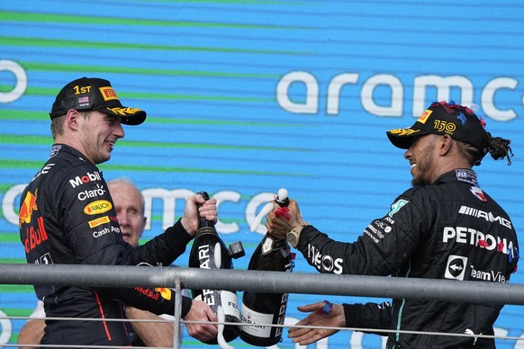 Red Bull driver Max Verstappen, left, of the Netherlands, and Mercedes driver Lewis Hamilton, right, of Britain, celebrate on the podium after the Formula One U.S. Grand Prix auto race at Circuit of t ...