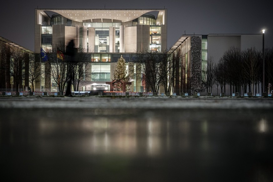 05.12.2023, Berlin: Passanten gehen am Abend am Bundeskanzleramt vorbei. Die Bundesregierung berät weiter über den Haushalt 2024. Foto: Kay Nietfeld/dpa +++ dpa-Bildfunk +++