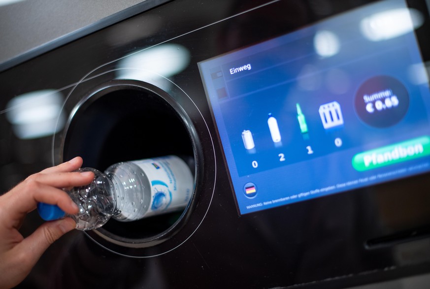 08.04.2019, Berlin: Ein Mann steckt eine Pfandflasche in einen Pfandflaschenautomaten in einem Supermarkt. Foto: Monika Skolimowska/dpa-Zentralbild/ZB