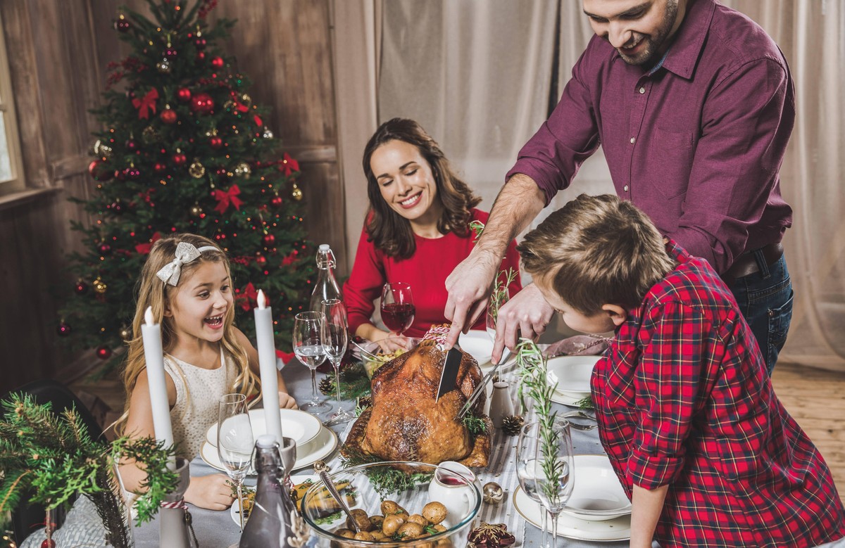 glückliche familie von vier mit gebratenen truthahn für weihnachten abendessen || Modellfreigabe vorhanden