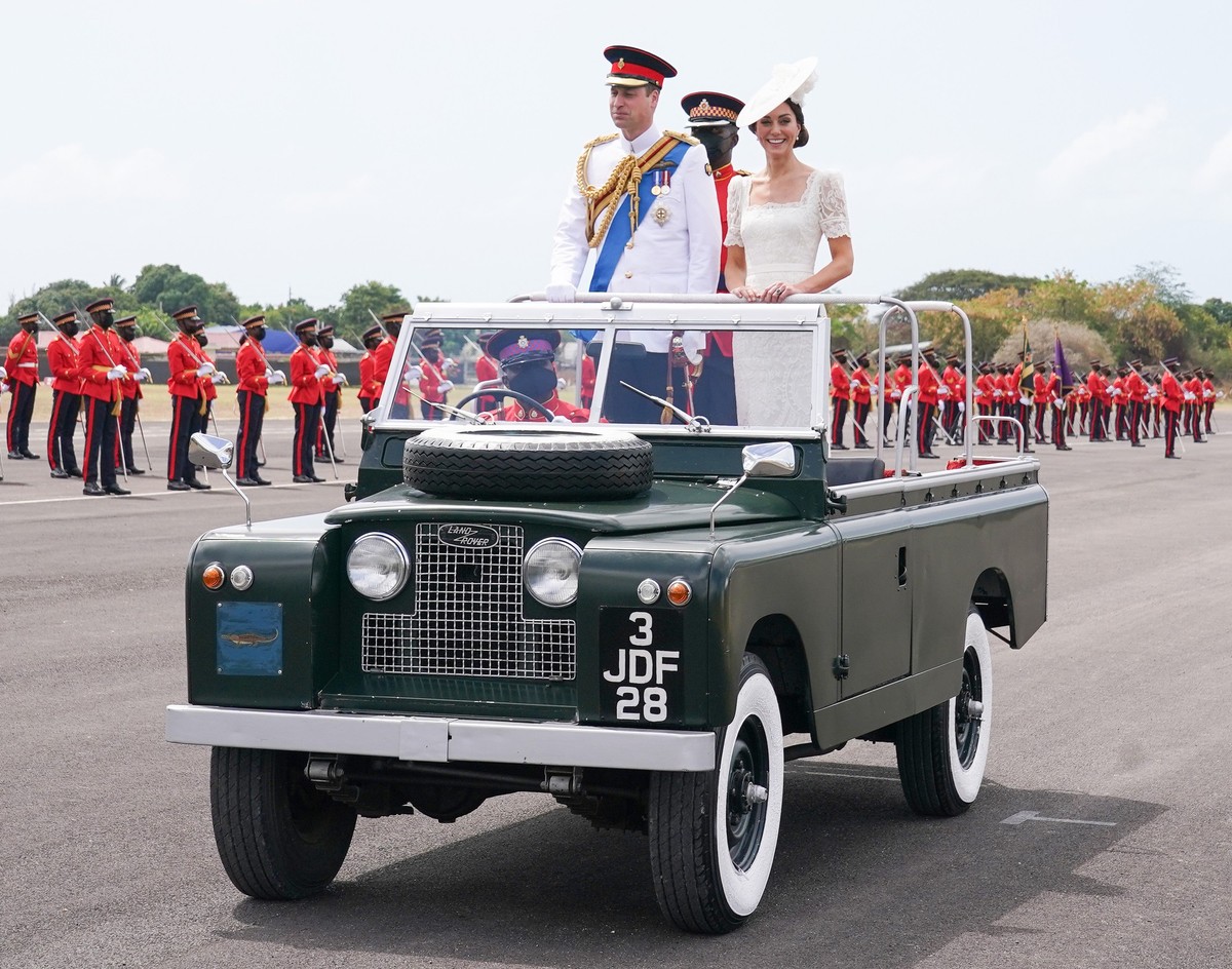 ARCHIV - 24.03.2022, Jamaika, Kingston: Prinz William (l), damaliger Herzog von Cambridge, und Kate (r), damaliger Herzogin von Cambridge, kommen in einem Auto zur Er�ffnungsparade der Offiziersanw�rt ...