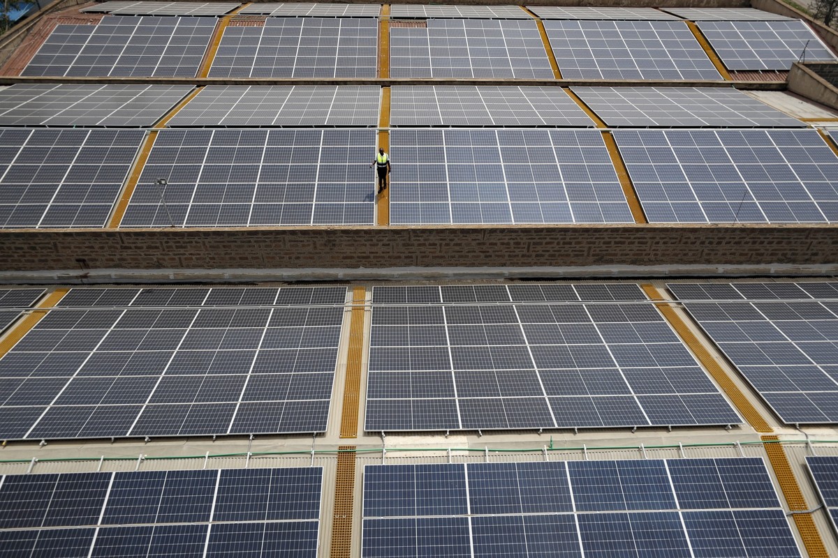 FILE - Mark Munyua, CP solar&#039;s technician, examines solar panels on the roof of a company in Nairobi, Kenya, Sept. 1, 2023. (AP Photo/Brian Inganga, File)