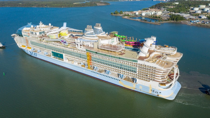 Worlds largest cruise vessel ICON OF THE SEAS departing for sea trials from Meyer Turku shipyard assisted by tug boats. High altitude back aerial view. Model Released Property Released xkwx aerial arc ...
