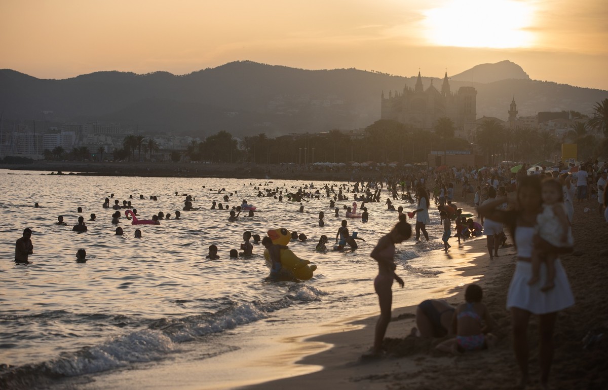 23.06.2025, Spanien, Palma: Menschen feiern die Johannisnacht am Strand Can Pere Antoni in Palma auf Mallorca. In dieser Nacht feiern die Bürger die Ankunft des Sommers am Strand, baden, beobachten de ...