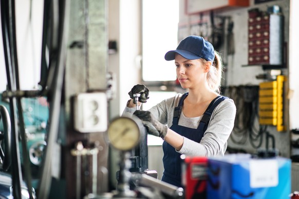 Female mechanic repairing a car. A woman in a garage.