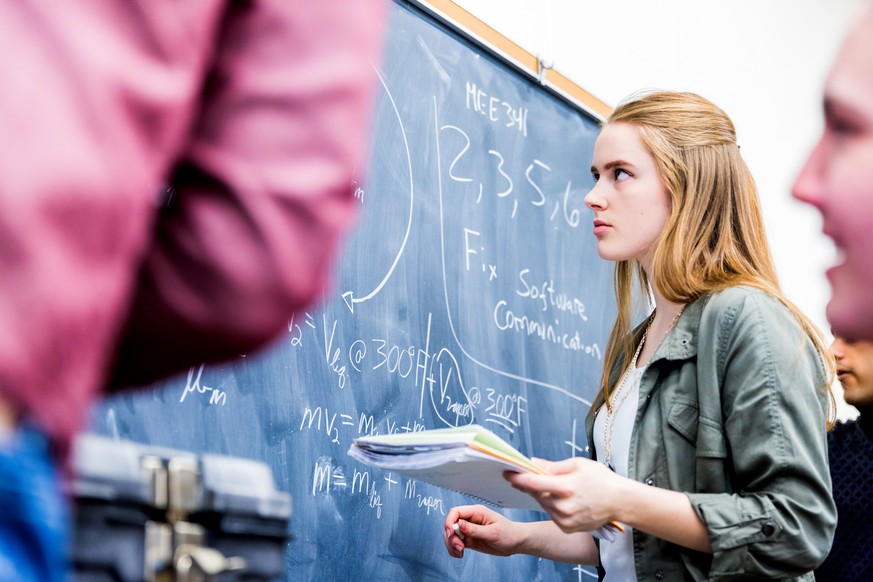 STEM, Education, University - Group of math class students brainstorming on a complex equation