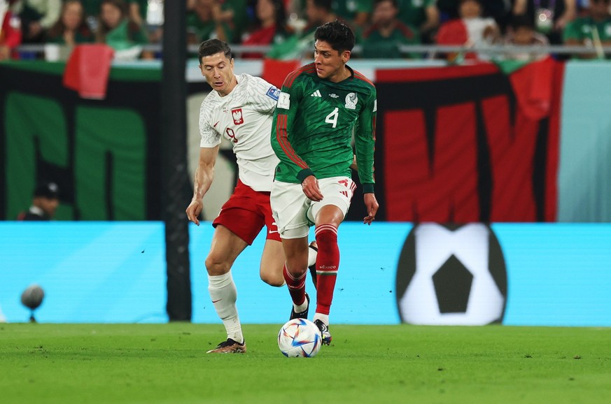 22.11.2022, Katar, Doha: Fußball: WM, Mexiko - Polen, Vorrunde, Gruppe C, 1. Spieltag, Stadion 974, Robert Lewandowski (l) von Polen gegen Edson Alvarez (r) von Mexiko. Foto: Christian Charisius/dpa + ...