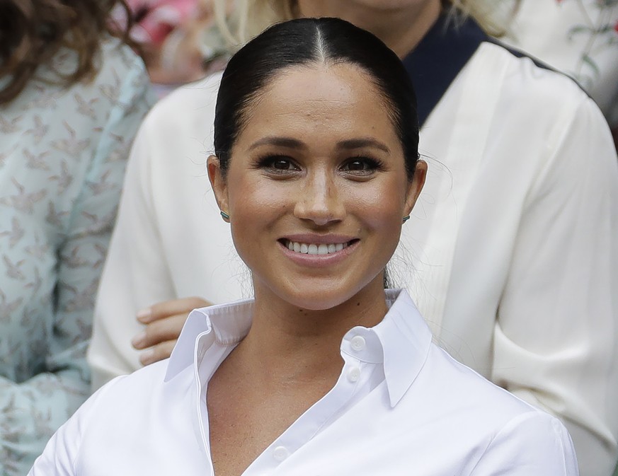 FILE - In this July 13, 2019 file photo Meghan, Duchess of Sussex smiles while sitting in the Royal Box on Centre Court to watch the women&#039;s singles final match between Serena Williams, of the Un ...