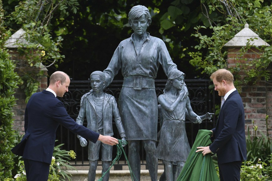 Britain&#039;s Prince William, left and Prince Harry unveil a statue they commissioned of their mother Princess Diana, on what woud have been her 60th birthday, in the Sunken Garden at Kensington Pala ...