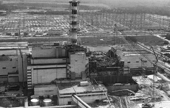 So sah der nach der Explosion zerstörte Reaktor 4 im August 1986 aus. Zu diesem Zeitpunkt errichtete man bereits eine Konstruktion aus Stahlbeton, um den offenen Reaktorkern und die daraus entweichend ...
