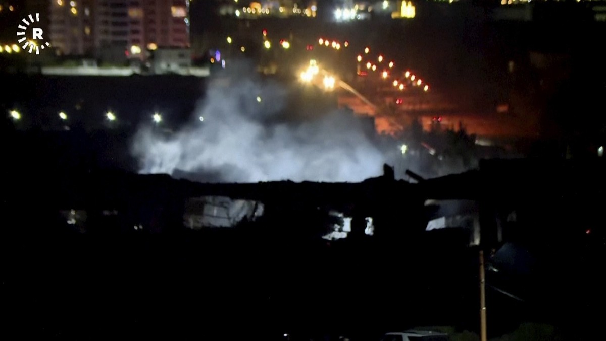 This image taken from video provided by Rudaw TV shows smoke rising from a building hit by a strike in Irbil, Iraq, Tuesday, Jan. 16, 2024. Iran has announced that it launched strikes against a “spy h ...