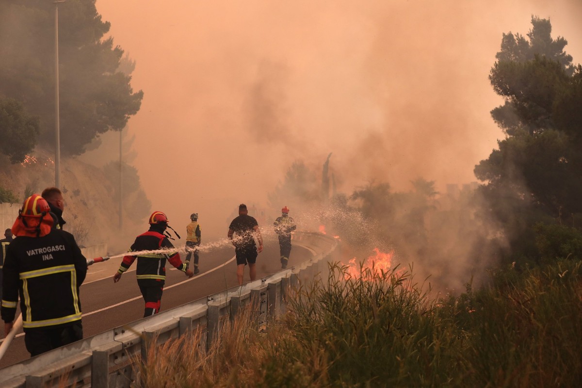 21.06.2025, Kroatien, Pisak: Feuerwehrleute l�schen Br�nde neben einer Stra�e. Ein heftiger Vegetationsbrand w�tet an der kroatischen Adria-K�ste und f�hrt dazu, dass viele Touristen fliehen. Foto: Iv ...