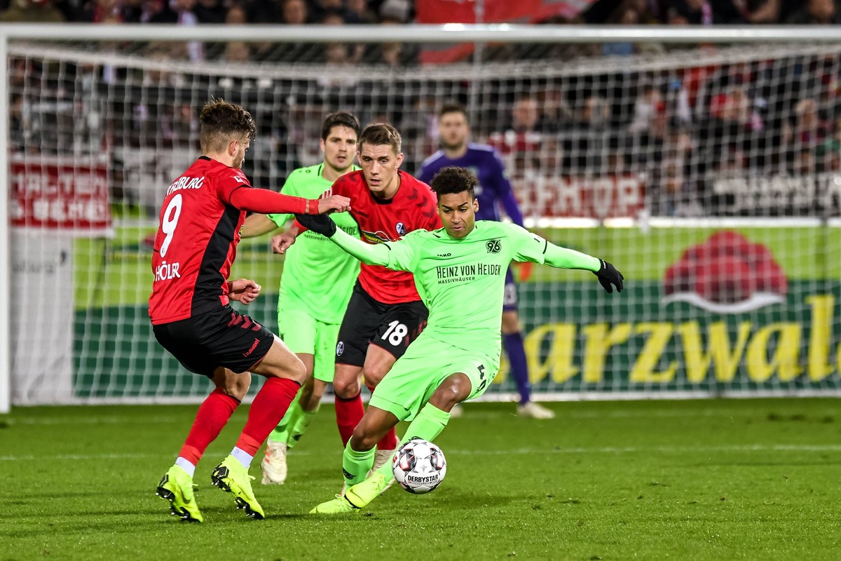 Fussball Bundesliga - 18/19 - SC Freiburg vs. Hannover 96 - 19-12-2018 Linton Maina (Hannover 96 40) im Zweikampf mit Lucas Hoeler (SC Freiburg 9) und Nils Petersen (SC Freiburg 18), beim Fussball Bun ...