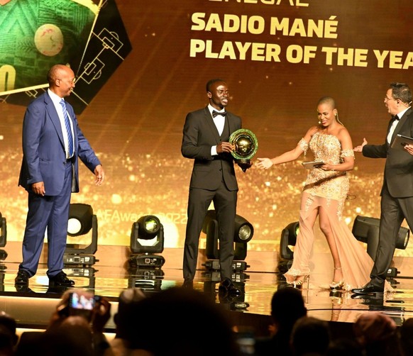 Patrice Motsepe, President of African Football Confederation (L) gives title to Sadio Mane (2nd L) of Senegal after winning the African Footballer of the Year award during the Confederation of African ...