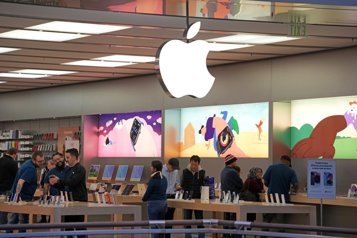 Customers shop in an Apple store in Pittsburgh Jan. 30, 2023. The Biden administration is taking aim at Apple and Google for operating mobile app stores that it says stifle competition. The finding is ...