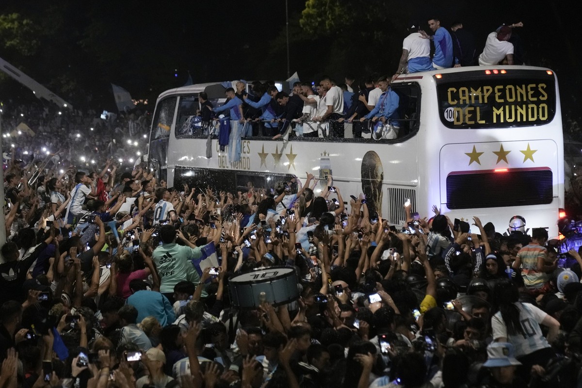 20.12.2022, Argentinien, Buenos Aires: Fans begr��en die Spieler der argentinischen Fu�ballmannschaft, die die Weltmeisterschaft gewonnen hat, nach ihrer Landung auf dem Flughafen Ezeiza in Buenos Air ...
