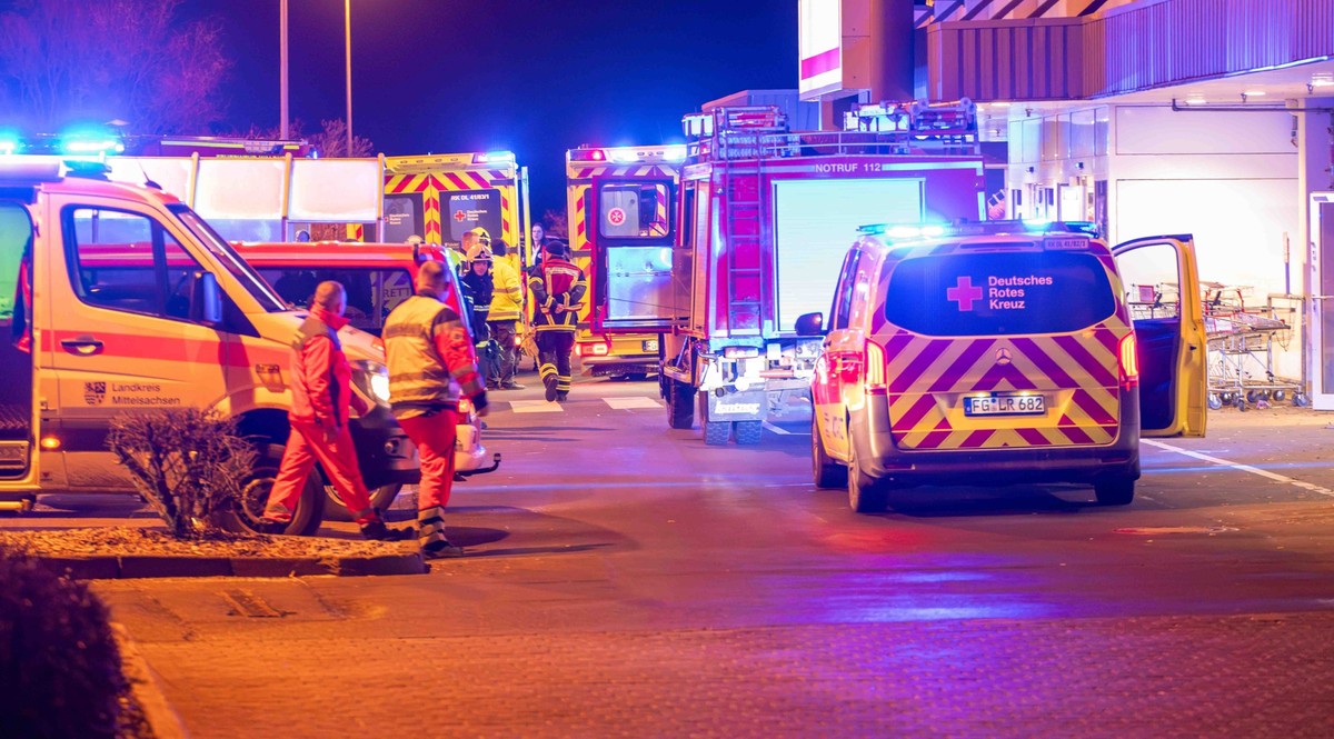 28.12.2024, Sachsen, Waldheim: Einsatzfahrzeuge stehen vor einem Supermarkt. Wegen einer noch unbekannten Substanz haben in dem Supermarkt im mittelsächsischen Waldheim Dutzende Kunden über Unwohlsein ...
