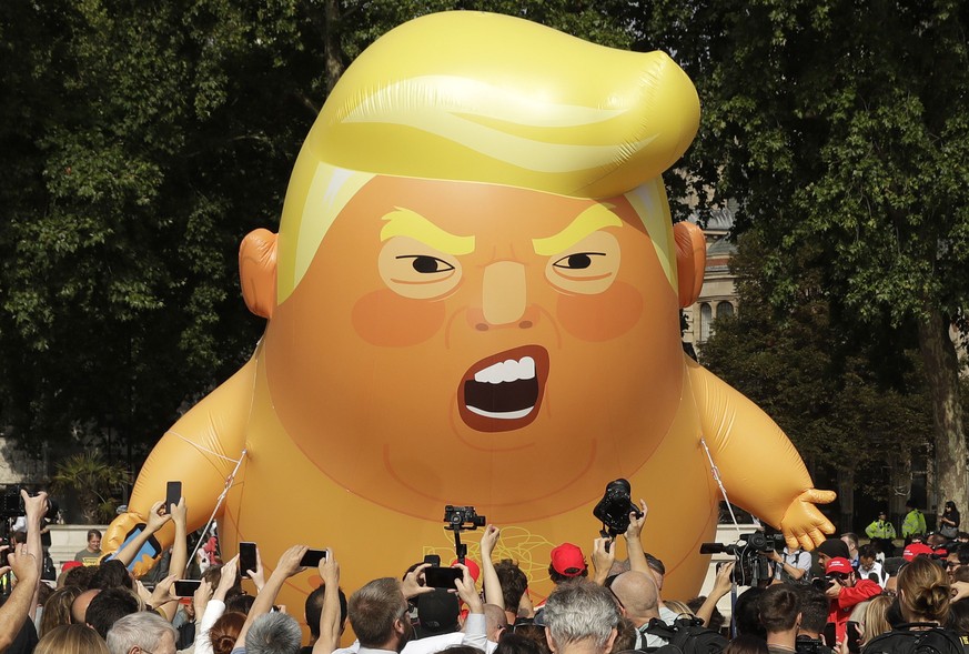 A six-meter high cartoon baby blimp of U.S. President Donald Trump is flown as a protest against his visit, in Parliament Square in London, England, Friday, July 13, 2018. Trump is making his first tr ...
