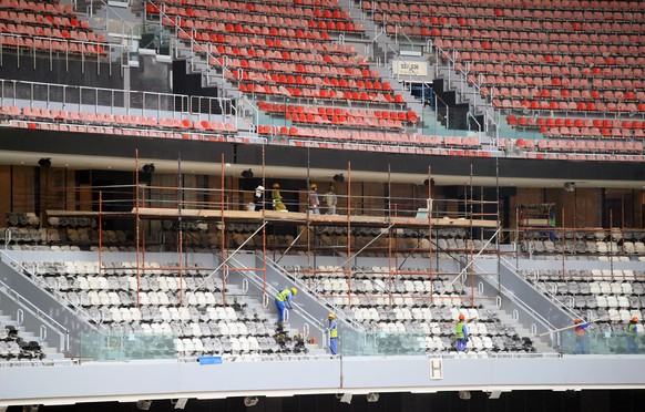Bauarbeiter mit letzten Arbeiten an der Tribüne im al-Bayt-Stadion, in dem das Eröffnungsspiel stattfindet.