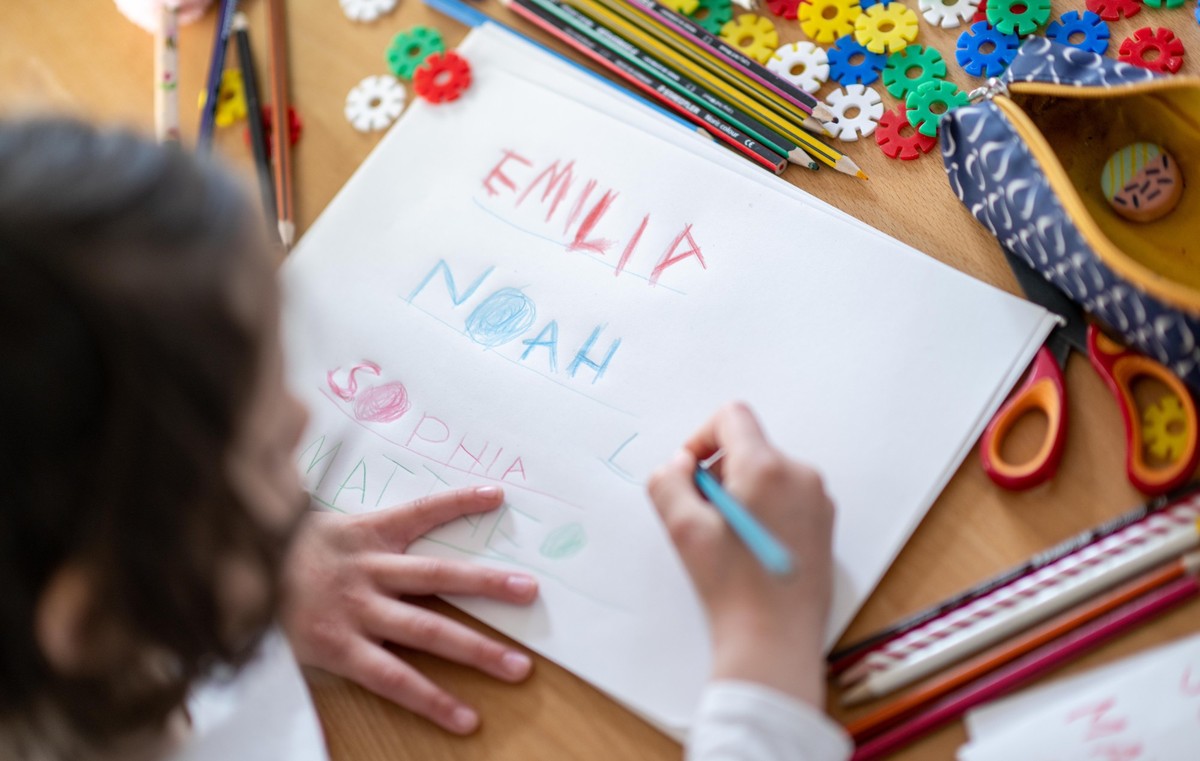 08.05.2023, Sachsen, Leipzig: Ein M�dchen schreibt die Vornamen Noah, Emilia, Sophia und Mattheo auf ein Blatt. Noah und Emilia sind die beliebtesten Erstnamen in Deutschland. Beide Namen verteidigen  ...