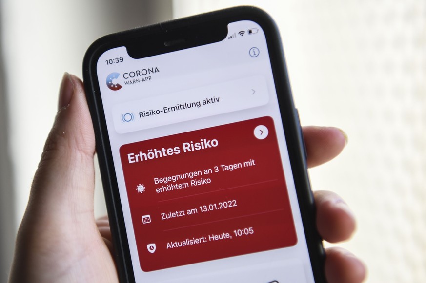 ARCHIV - 19.01.2022, Berlin: Auf einem Smartphone zeigt die geöffnete Corona-Warn-App ein erhöhtes Risiko an. Die rote Anzeige warnt vor drei Begegnungen mit Corona-positiv getesteten Personen. (zu pd ...