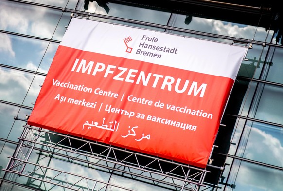 Ein Schild mit der Aufschrift „Impfzentrum“ in mehreren Sprachen hängt über dem Eingang des Impfzentrums in der Messehalle an der Bürgerweide.