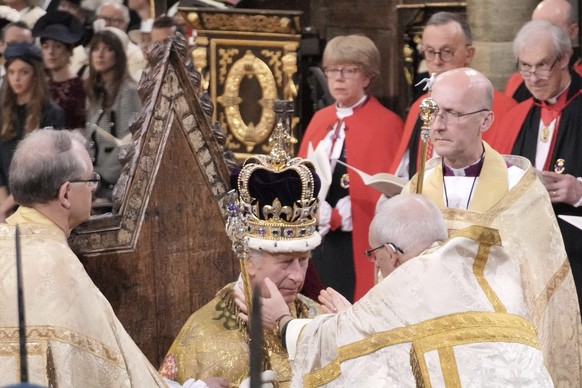 King Charles III sits as he is crowned with St Edward&#039;s Crown by The Archbishop of Canterbury the Most Reverend Justin Welby during the coronation ceremony at Westminster Abbey, London, Saturday, ...