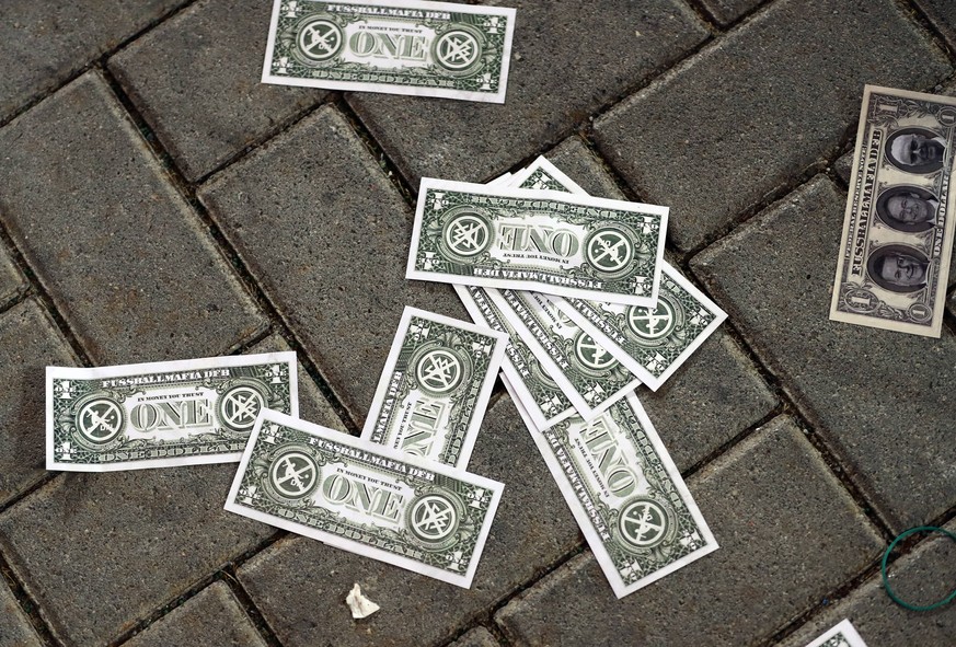 Zaster auf dem Pflaster: Falsche Dollarnoten als Protest gegen die Geldgier der Verbände.