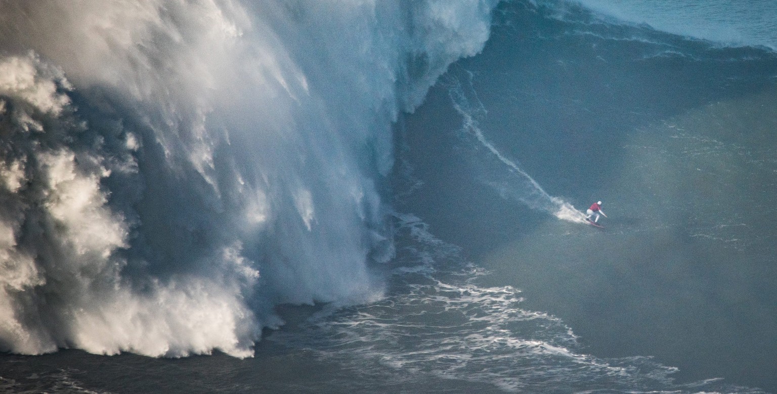 ARCHIV - 01.10.2018, Portugal, Nazare: Maya Gabeira aus Brasilien surft eine 20,72 Meter hohe Welle. Die Brasilianerin hat 2020 ihren eigenen Weltrekord f