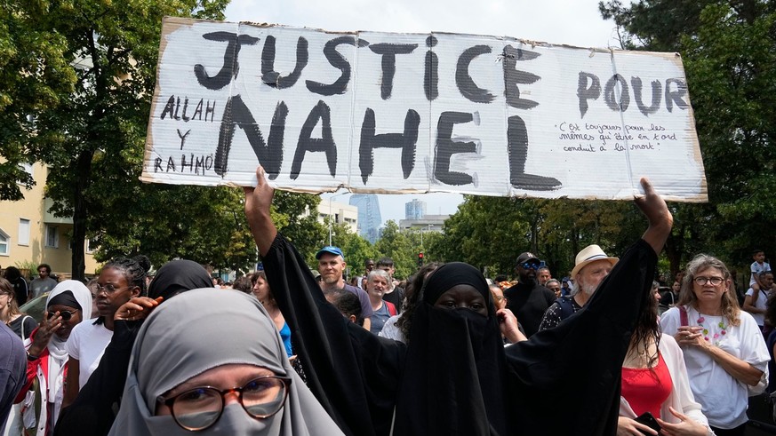 FILE - A woman shows a poster &quot;Justice for Nahel&quot; during a march for 17-year-old Nahel, Thursday, June 29, 2023 in Nanterre, outside Paris. Officially, race doesn&#039;t exist in France. But ...