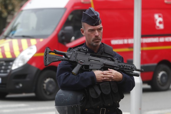 13.10.2023, Frankreich, Arras: Ein Polizist steht Wache, nachdem ein Messerangreifer einen Menschen in einem Gymnasium getötet und mehrere verletzt hat. Der Täter sei von der Polizei festgenommen word ...