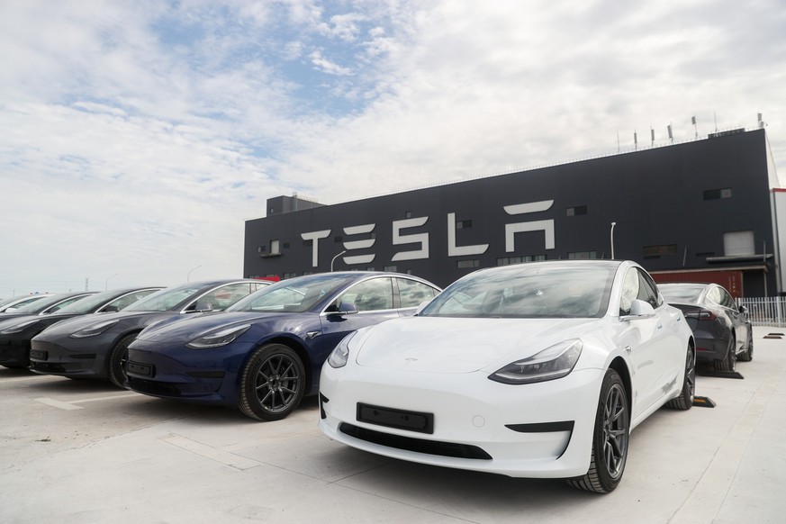 ARCHIV - 26.10.2020, China, Shanghai: Fahrzeuge des Models 3 stehen vor der Tesla Fabrik in Shanghai. Der US-Autobauer Tesla muss bei mehr als 1,6 Millionen Fahrzeugen in China nachjustieren. (zu dpa: