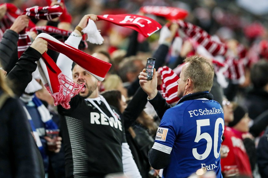 Auswaerts Fan filmt die Fans der Heimmannschaft bei der Hymne , 1. FC Koeln - FC Schalke 04, DFB regulations prohibit any use of photographs as image sequences and/or quasi-video. 1. FC Koeln - FC Sch ...