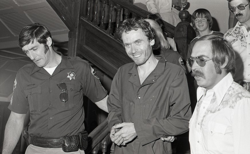In this 1977 photo serial killer Ted Bundy, center, is escorted out of court in Pitkin County, Colo. The Glenwood Springs Post-Independent discovered the 40-year-old photo of Bundy, along with others, ...