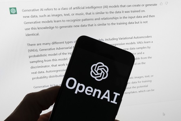 FILE - The OpenAI logo is seen on a mobile phone in front of a computer screen displaying output from ChatGPT, on March 21, 2023, in Boston. The Italian government’s privacy watchdog said Friday March ...