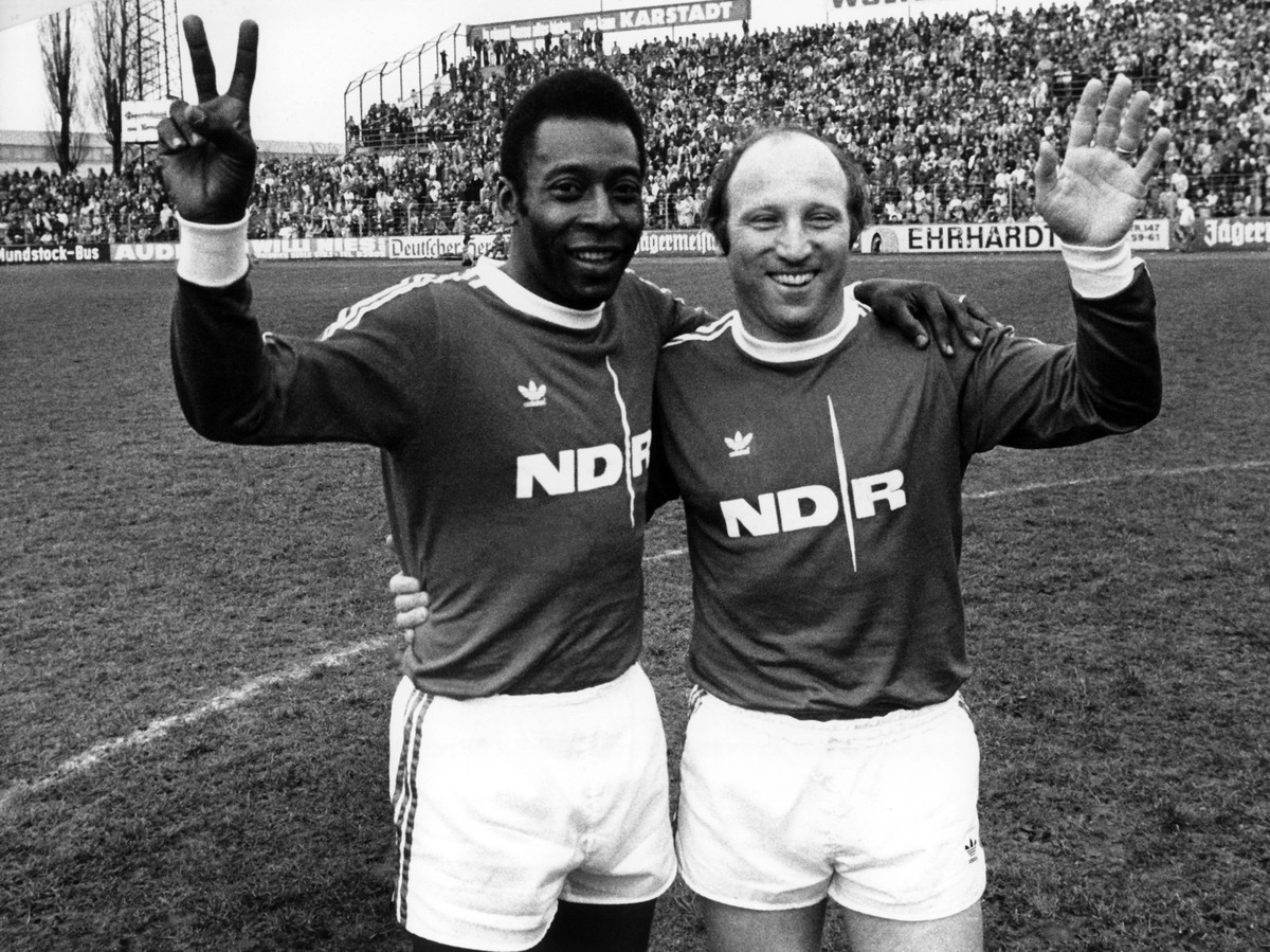 ARCHIV - 21.04.1975, Niedersachsen, Braunschweig: Der Ehrenspielf�hrer der deutschen Fu�ball Nationalmannschaft, Uwe Seeler (r), und die brasilianische Fu�ball-Legende Pele winken bei einem Benefizspi ...
